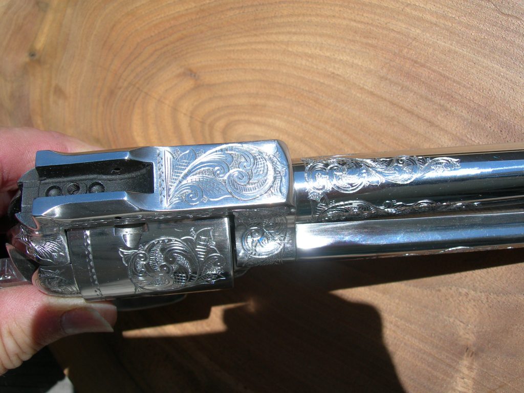 Detail work on a JRH custom 10mm Ruger featuring close up American Scroll engraving details.