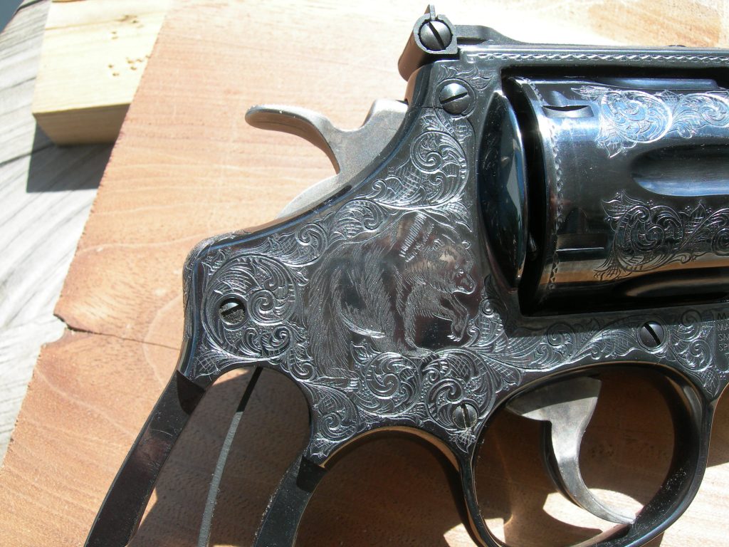A close-up image of a Smith & Wesson Model 57 featuring American Scroll engraving and a Grizzly Bear.
