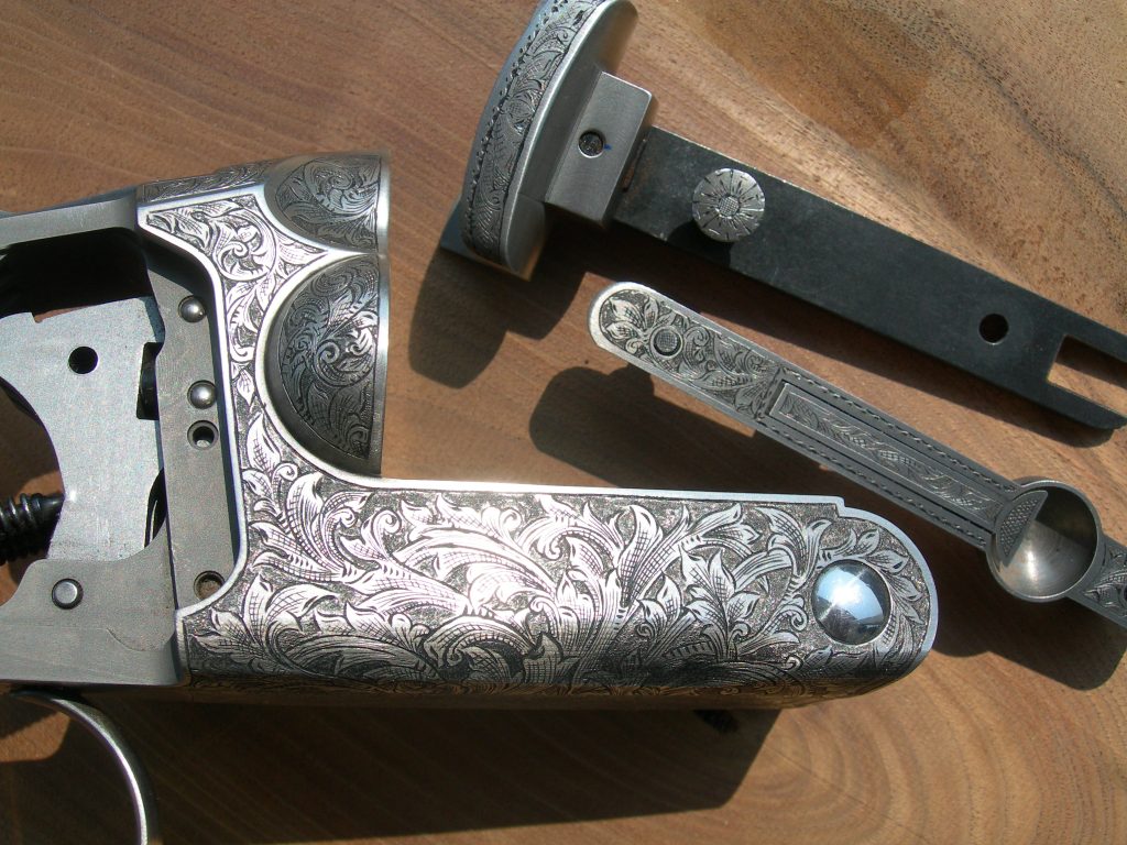 Unique 3 barrel shotgun featuring ornate foliate engraving and inked cuts throughout.