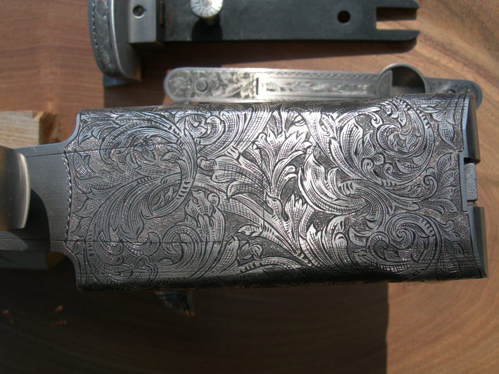 Unique foliate engraving with inked cuts on a Charles Daly 12 Gauge shotgun with 3 barrels.