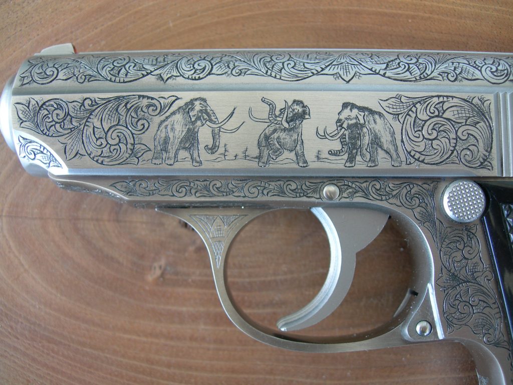 Finished engraving of an InterArms PPK/S featuring American Scroll engraving and mammoths.