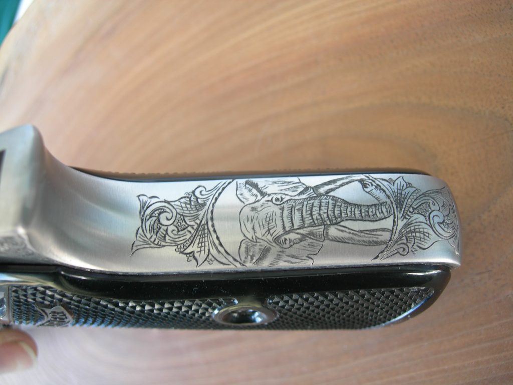 An elephant head surrounded by an American Scroll engraved frame on an InterArms PPK/S